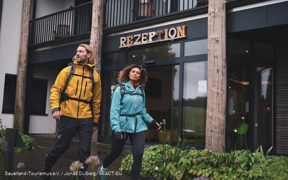 Zwei Wanderer starten ihre Wanderung am Hotel vor der Rezeption