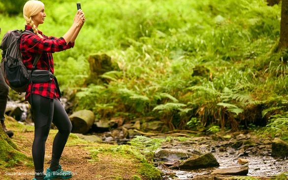 Wandererin macht ein Selfie am Bach am Sauerland-Höhenflug