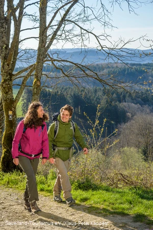 Zwei Wanderer wandern fröhlich nebeneinander oberhalb von Attendorn in Windhausen